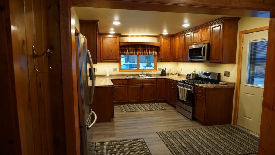 Kitchen with stainless steel gas stove, refrigerator, microwave, & dish washer.
