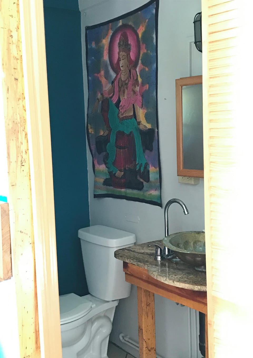 The water closet with a batik from Thailand and hammered brass sink from Morocco