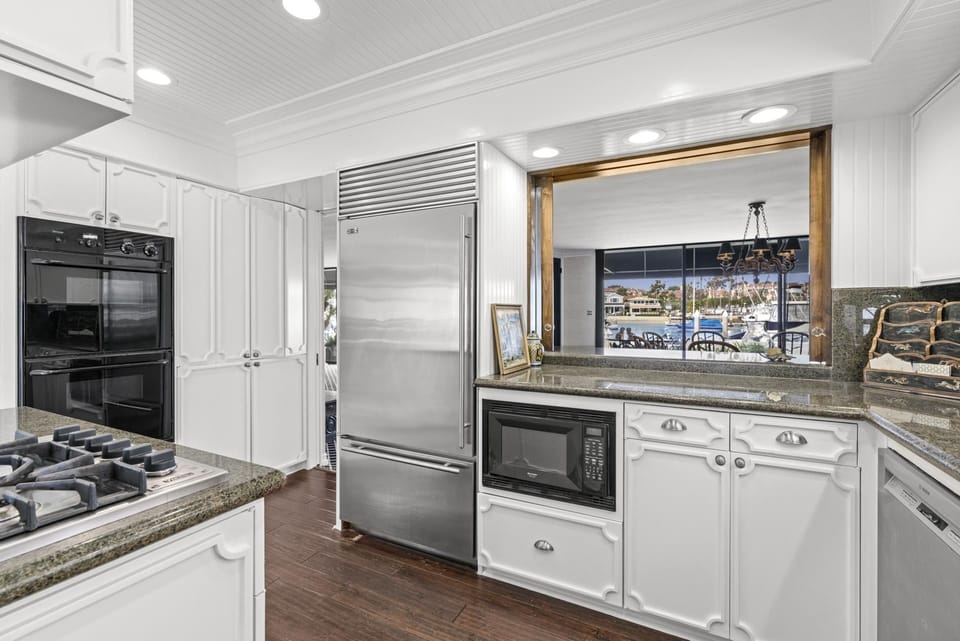 Located off of the dining area is the kitchen, with top-of-the-line appliances, views of the courtyard and dining area, butler's pantry with secondary fridge and freezer, plenty of storage - an ideal set-up for easy meal prep.
                