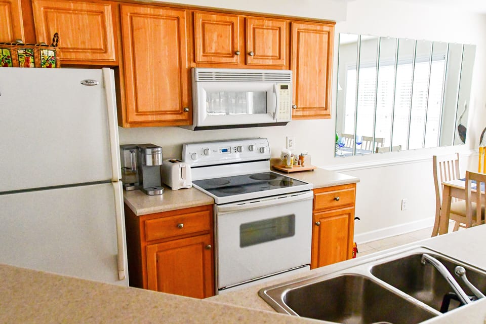 Villa Kitchen with range, microwave, Keurig, refrigerator, dishwasher, and sink.