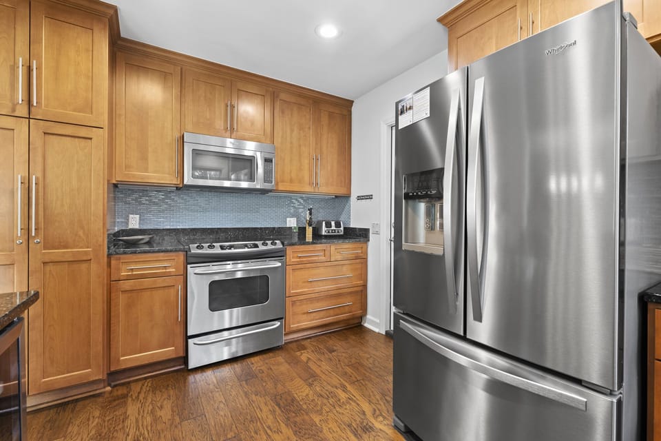 Full equipped kitchen with stove, microwave, dishwasher, fridge, bar seating for 4 and a door leading out to the screened in porch