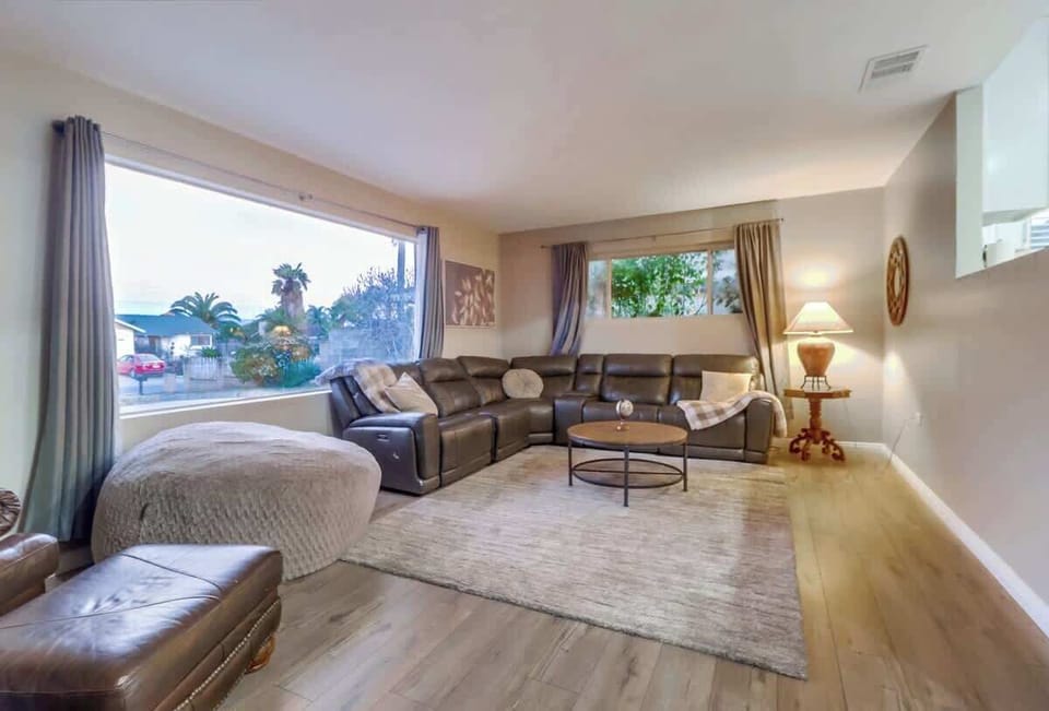 The living room features a huge picture window, sectional sofa, & giant beanbag