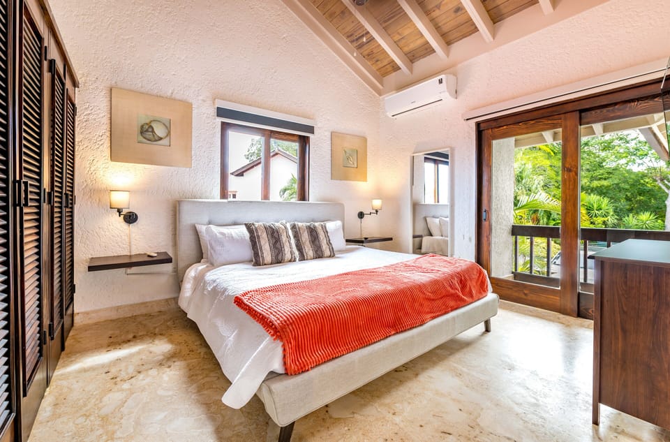 2nd bedroom with king bed, en suite full bath, and balcony overlooking courtyard