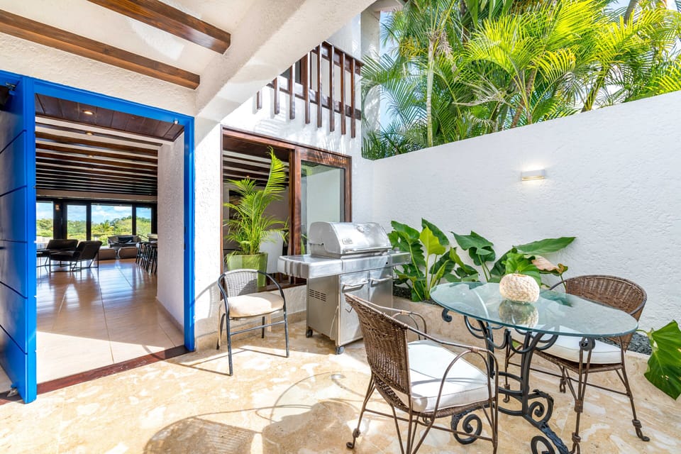 Outdoor courtyard with BBQ grill and seating area (bright blue front door!)