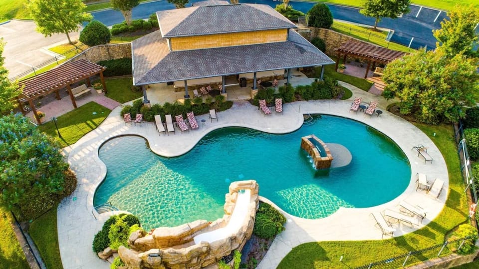 The amazing pool with a water slide & plenty of lounge chairs.