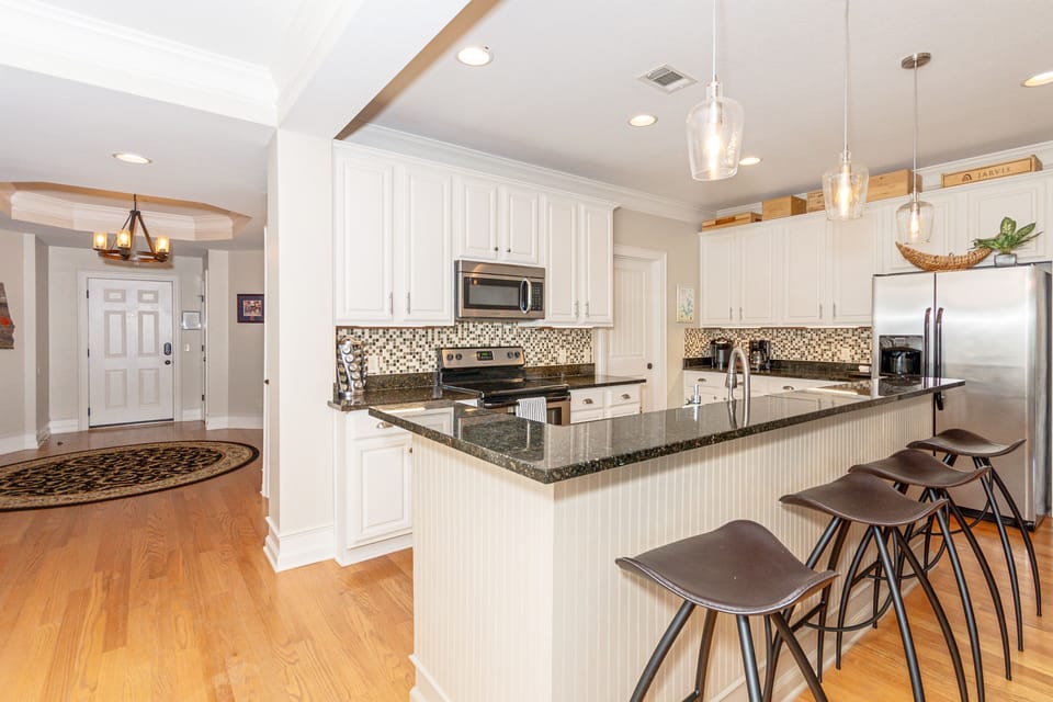 Granite countertops, bar seating, stainless steel appliances, electric cooktop.