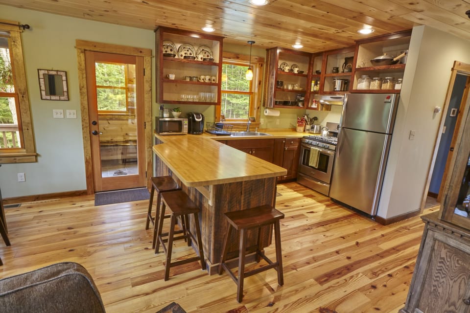 Three bar stools around the butcher block counter top provide extra seating.