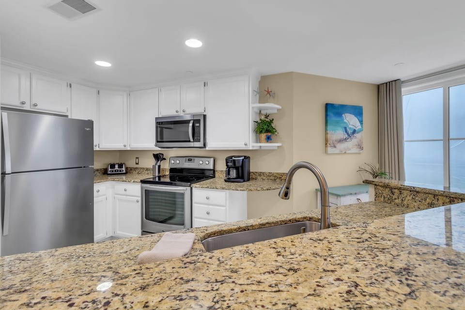 The beautiful kitchen features granite counter tops and stainless appliances