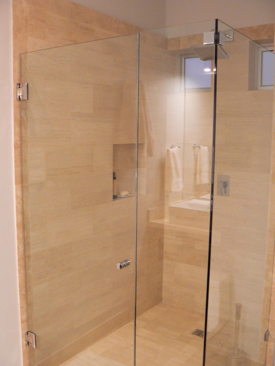 Master walk-in shower with waterfall showerhead surrounded by marble