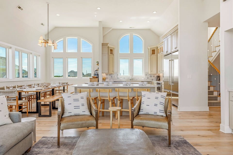 You'll love gathering in this bright, open living space where coastal elegance meets comfort. The kitchen island invites group meals, while natural light and ocean breezes fill every corner.