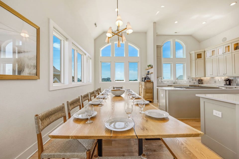 Gather around this stunning farmhouse table for memorable meals bathed in natural light. The vaulted ceilings and arched windows create an airy, inviting atmosphere where you'll love sharing stories and laughter with your group.
