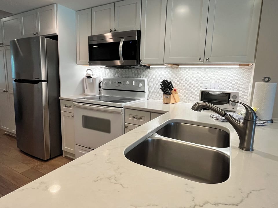 Another view of kitchen. Fully stocked with microwave, dishwasher and fridge.