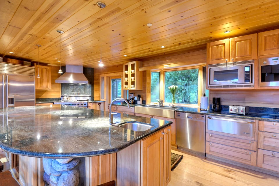 Chef’s kitchen with granite counters and natural wood finishes.