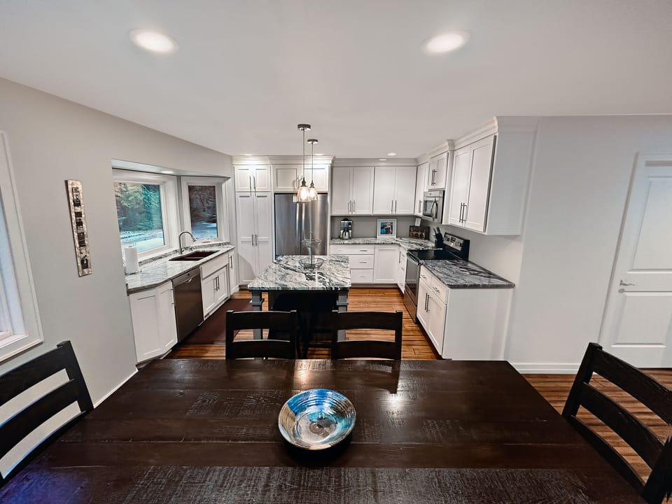 Fully stocked kitchen with large table and island bar seating. Adjoining sunroom