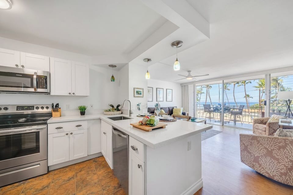 Spacious kitchen equipped with stainless steel appliances and white cabinetry