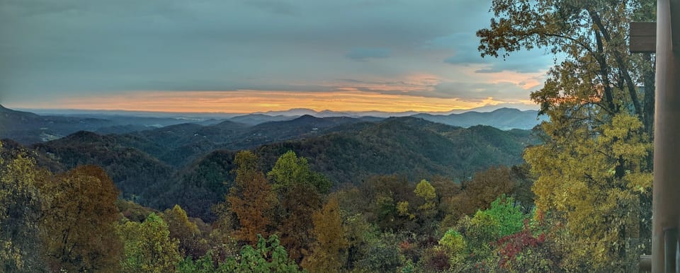 - Stunning Smoky Mountain sunset over rolling forested hills   - Golden skies reflect the peaceful beauty of nature’s landscape   - Ideal view for capturing the magic of mountain evenings