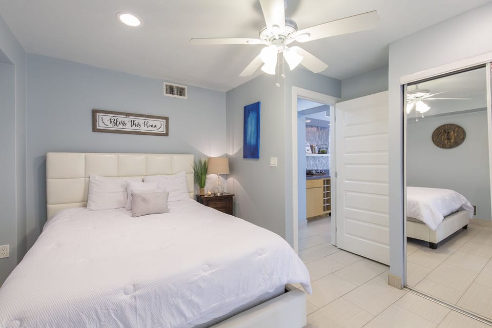 Comfortable queen bedroom with sliding glass doors leading outside.