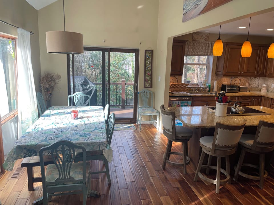 Fully stocked kitchen w/ dining area looking out to private deck & propane grill