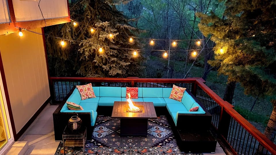 Dreamy outdoor living. Stylish seating, fire pit, and twinkling lights. 