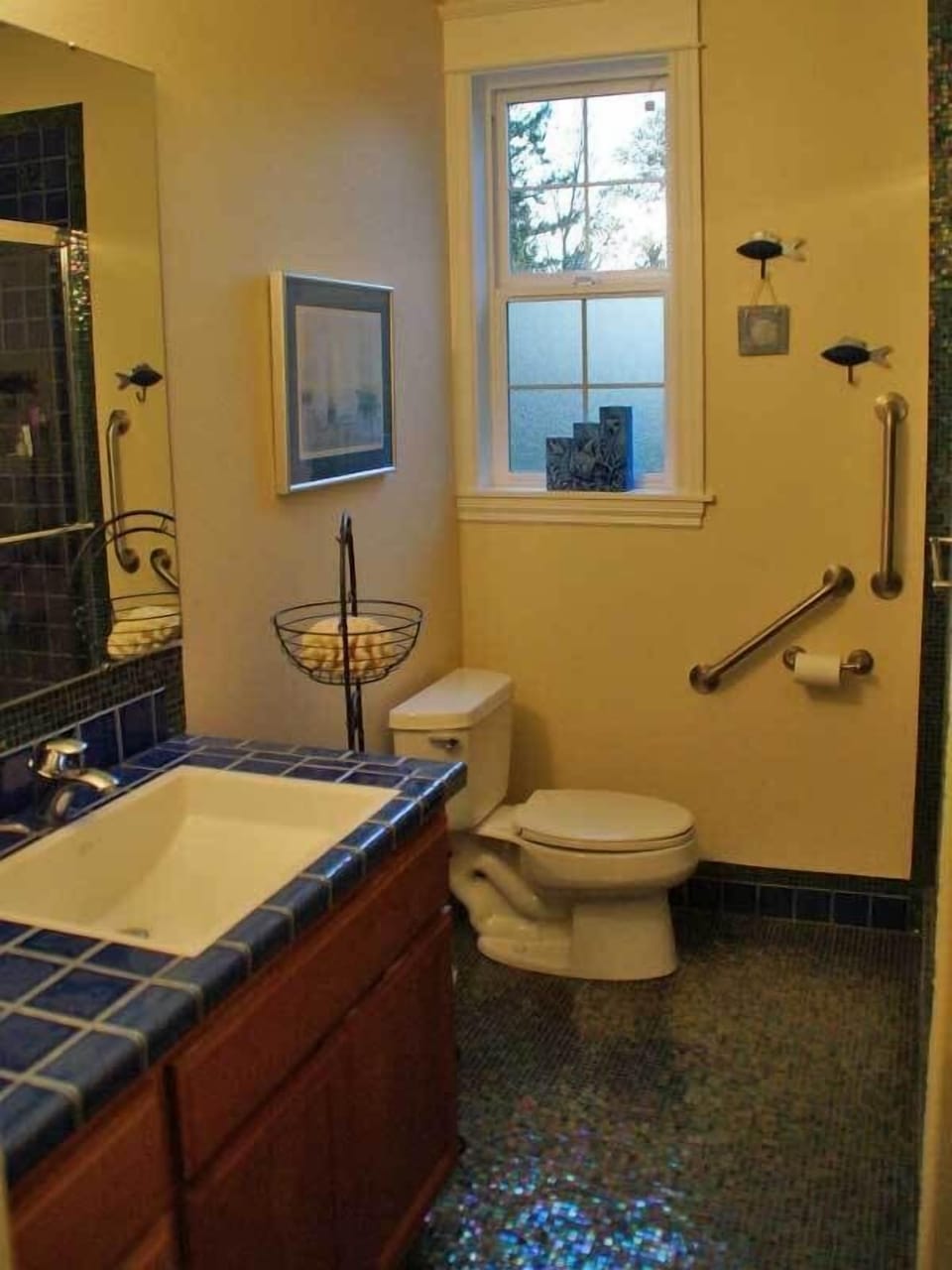 Beautiful clean aquatic themed bathroom: custom tile, grab bars, walk in shower.