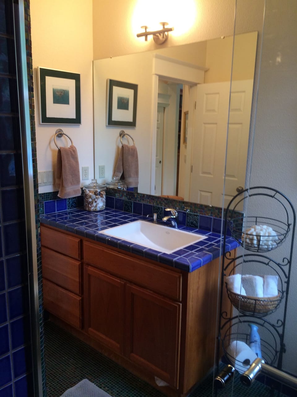 Super clean vanity & large wall mirror enhance the cheery decor of the bathroom.