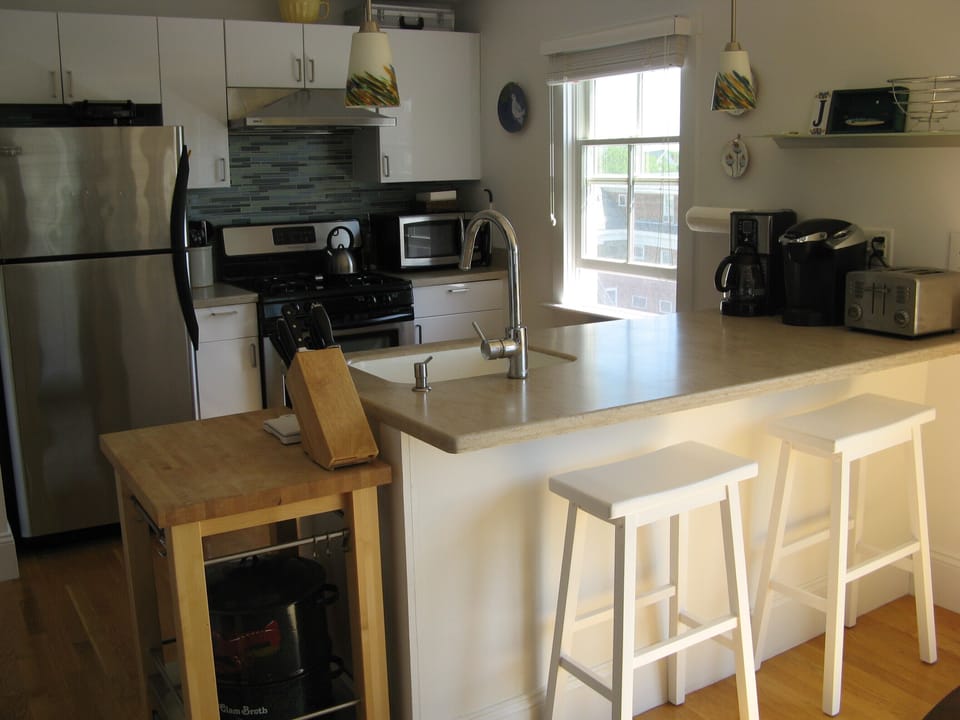 Breakfast bar and kitchen with all stainless steel appliances.