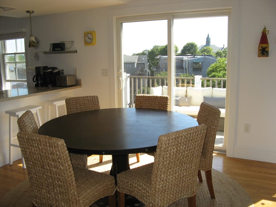 View of dining area with deck and outdoor living space in the background.