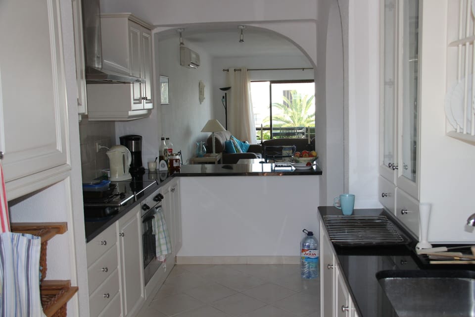 Galley kitchen with granite worktops and home from home appliances for cooking.
