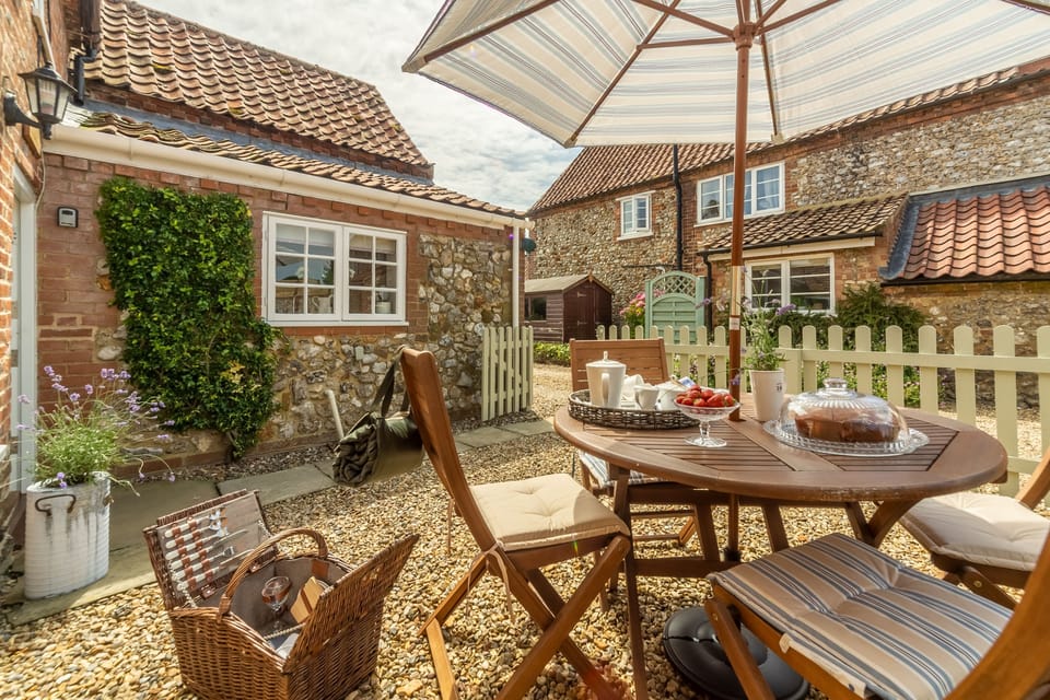 Enclosed courtyard with table and seating is a little sun trap