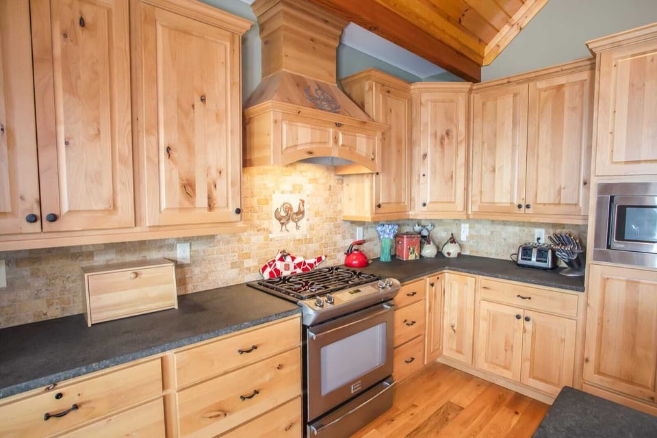 Large Kitchen Features Tasteful Wooden Cabinets and Gas Cooktop