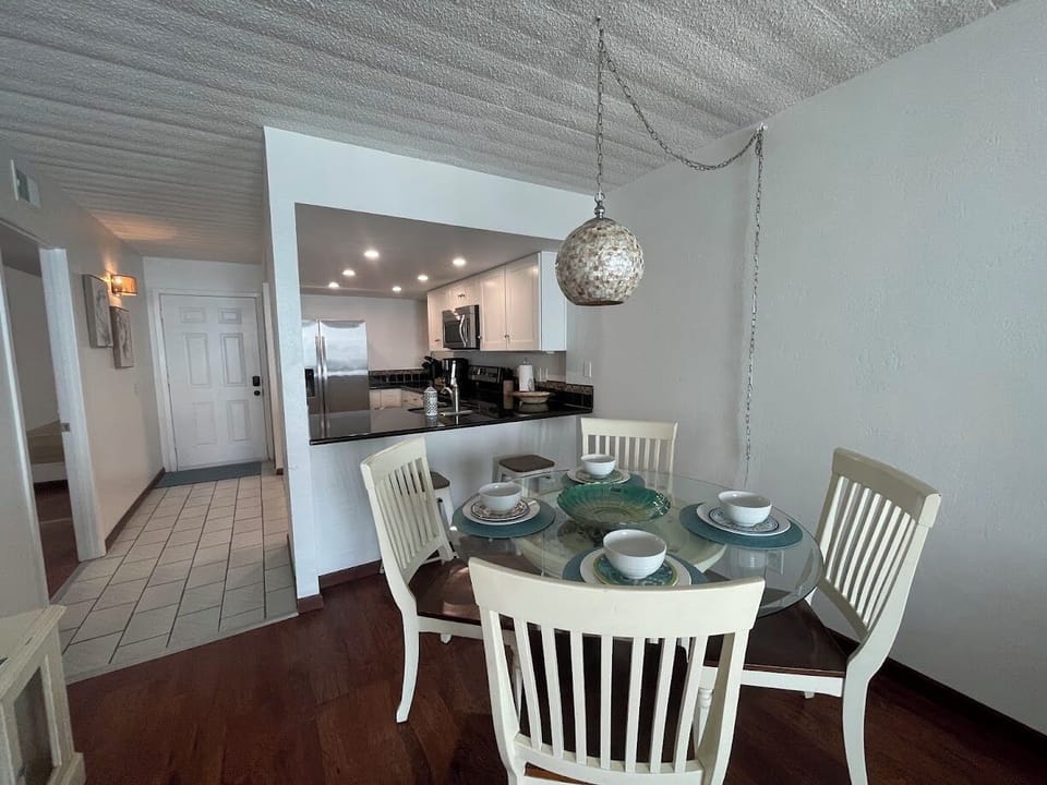 Dining table with room for four plus two barstools at the kitchen bar. 