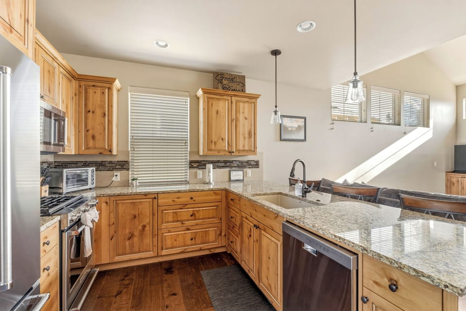 KitchenAid gas range, tile backsplash, and full stainless suite.