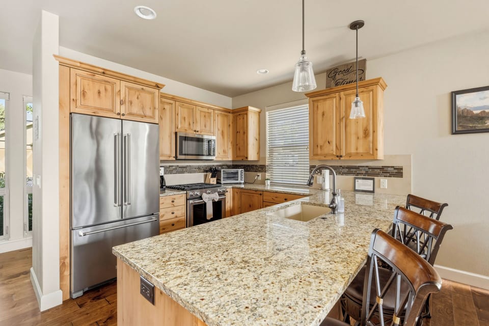 Granite counters, KitchenAid appliances, gas range, custom knotty alder cabinets