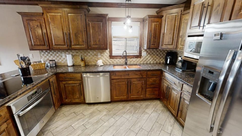 Your fully equipped kitchen features rich wood cabinetry, granite countertops, stainless steel appliances, and everything you need to create memorable meals together during your stay.