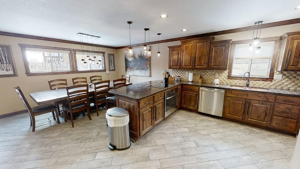 Picture yourself cooking and gathering in this spacious kitchen, where rich wood cabinetry, granite counters, and a generous island invite you to create meals together.