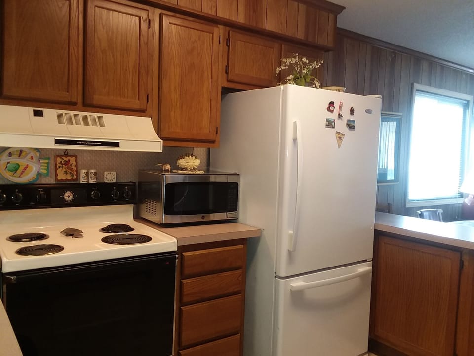 Large stove, refrigerator with large deep freezer, and bran new microwave.