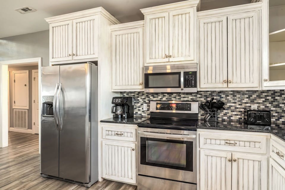 Your fully equipped kitchen features modern appliances and elegant white cabinetry, perfect for preparing memorable meals during your stay.