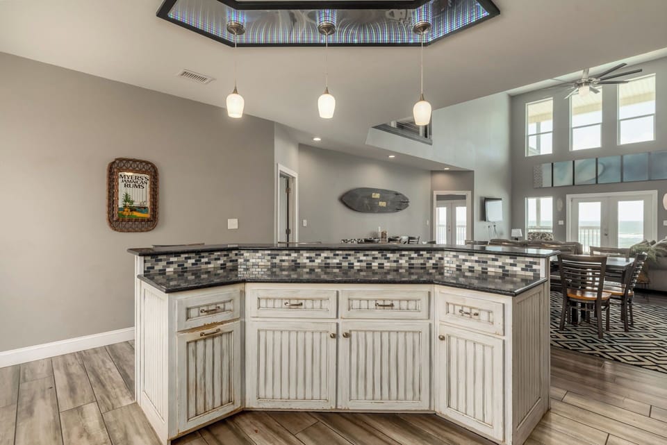 Your spacious kitchen island awaits with granite counters and mosaic tile backsplash, perfect for gathering and meal prep.