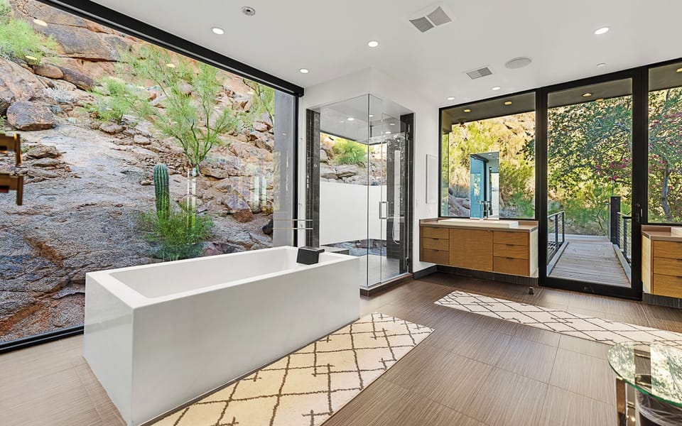 Modern bath with natural light, sleek finishes & seamless indoor-outdoor flow.