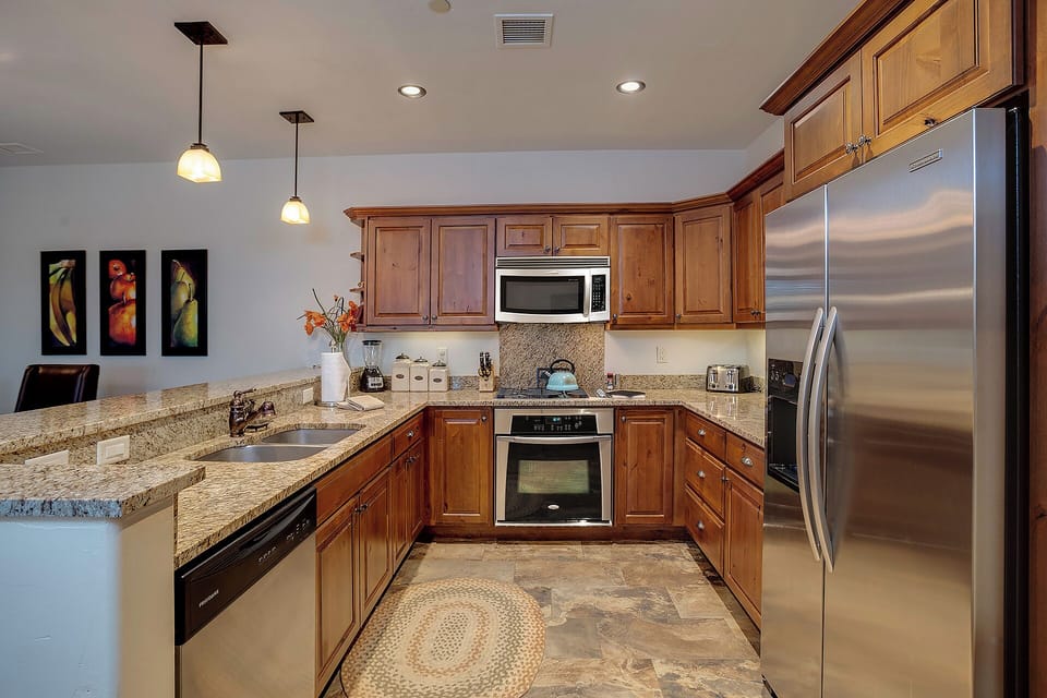 You'll love preparing meals in this fully equipped kitchen with granite countertops, stainless steel appliances, and warm wood cabinetry.