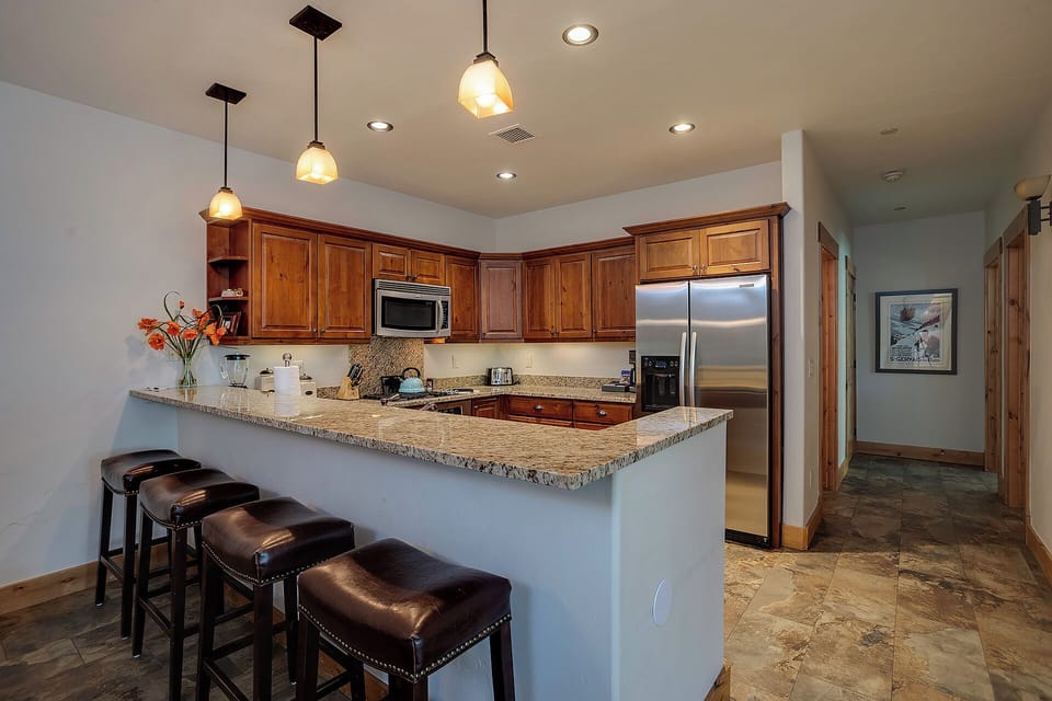 Your fully equipped kitchen features granite countertops, stainless steel appliances, and a breakfast bar perfect for casual meals.