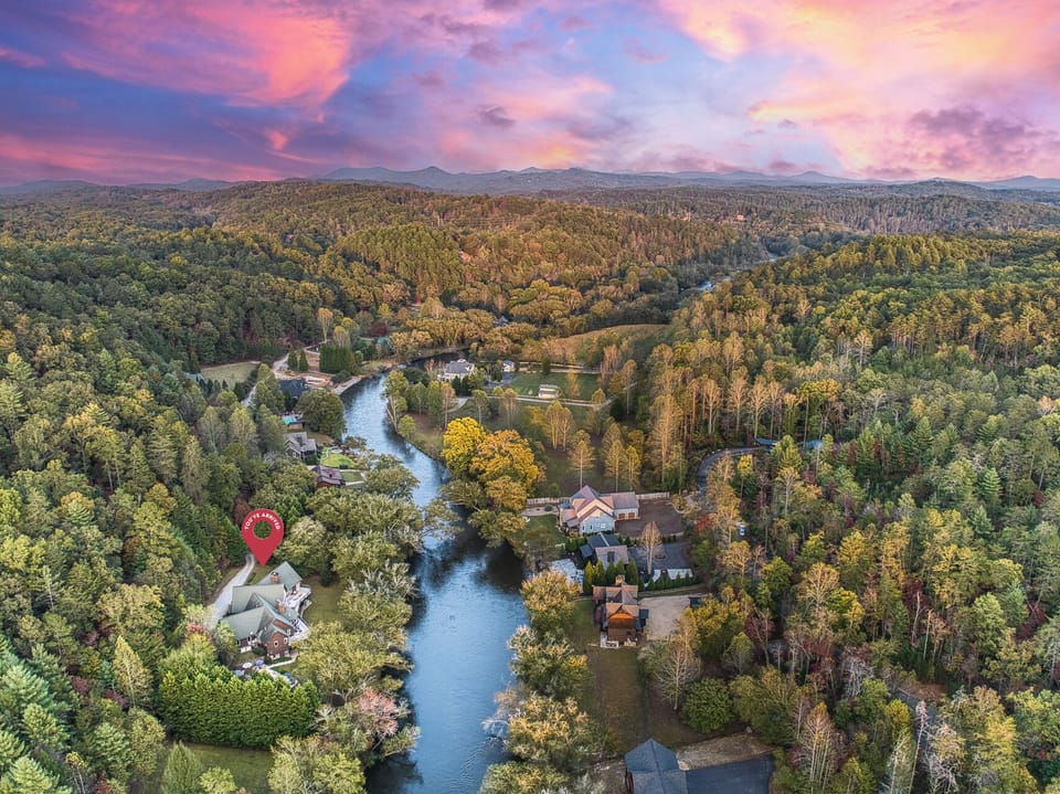 Nestled on the stunning Toccoa River, our 9-bedroom lodge features a custom fire pit, a large hot tub, a pool, a large movie theater, a full bar, games, a wine room, and expansive decks!