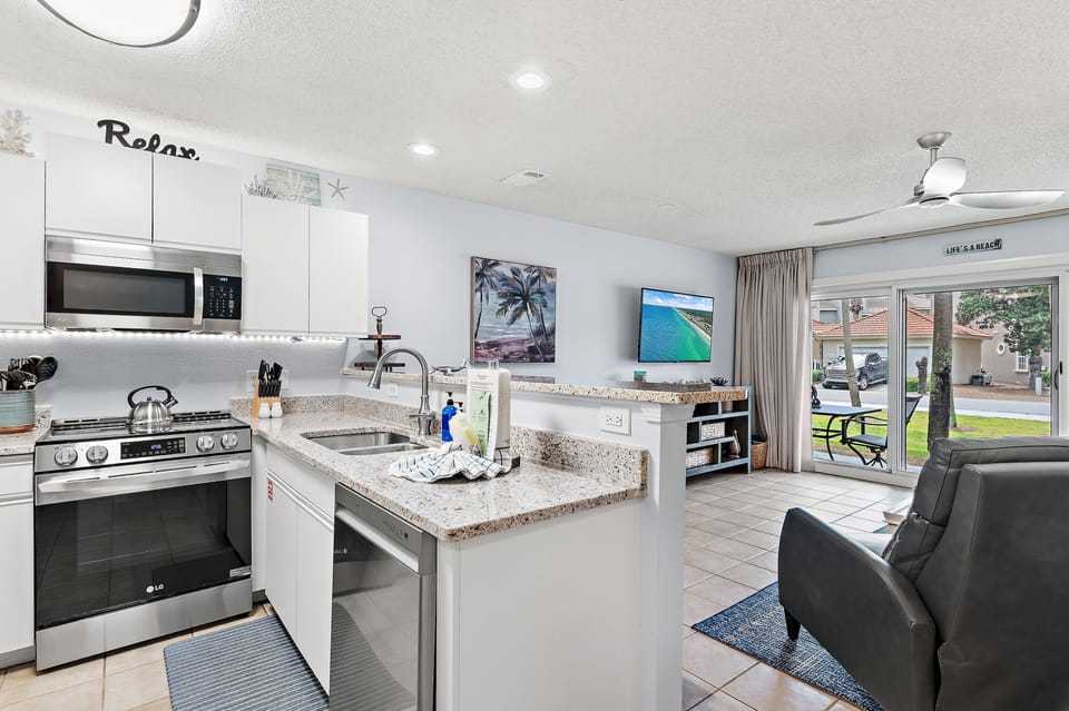 A bright kitchen with granite counters and bar seating.