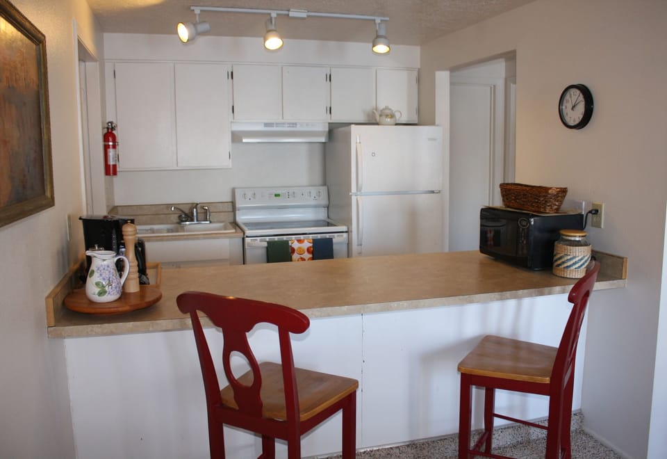 Galley kitchen and breakfast or serving bar. 