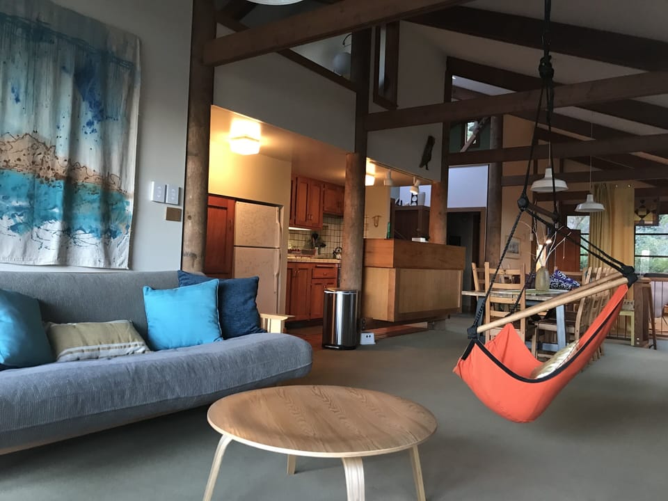 Main living area has floor to ceiling windows with views of the bay and woods