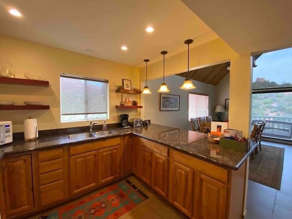 Another view of kitchen, bar area and dining room table looking toward views.