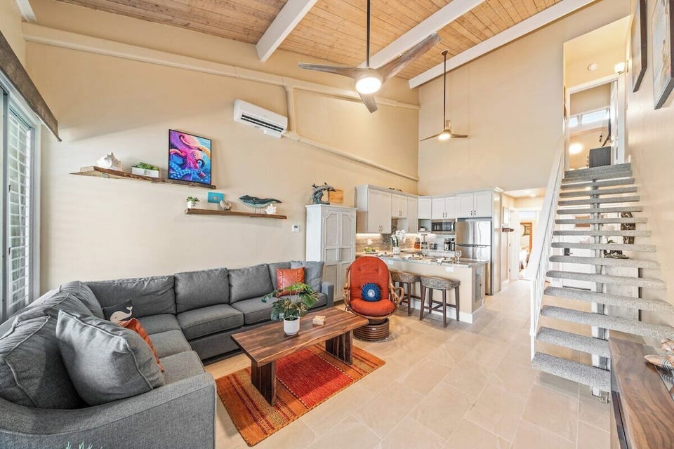 Wide view of the living area highlighting seating, kitchen, and lanai access.