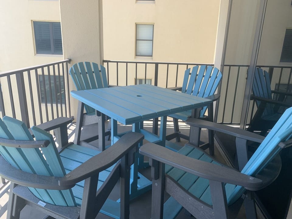 Polywood table and 4 comfortable high back chairs on beachfront balcony