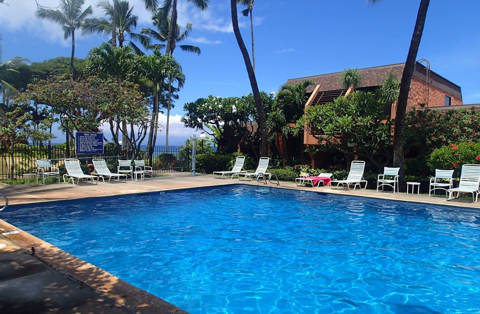 Large heated pool with lots of lounge chairs 