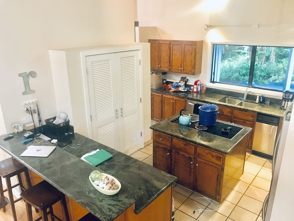 Two story open concept kitchen with stainless adjacent living room, pool table